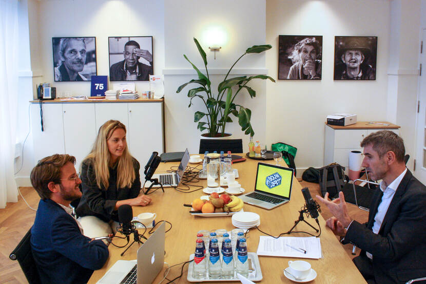 Foto van Paul Blokhuis die een podcast inspreekt met twee personen die interviewen
